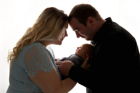 backlit newborn photo of family