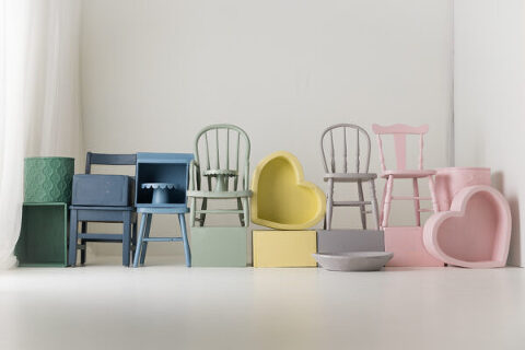 a stack of chairs, boxes and cake plates painted in a rainbow of colors